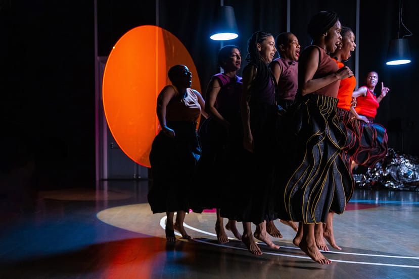 group of seven dancers jump in unison